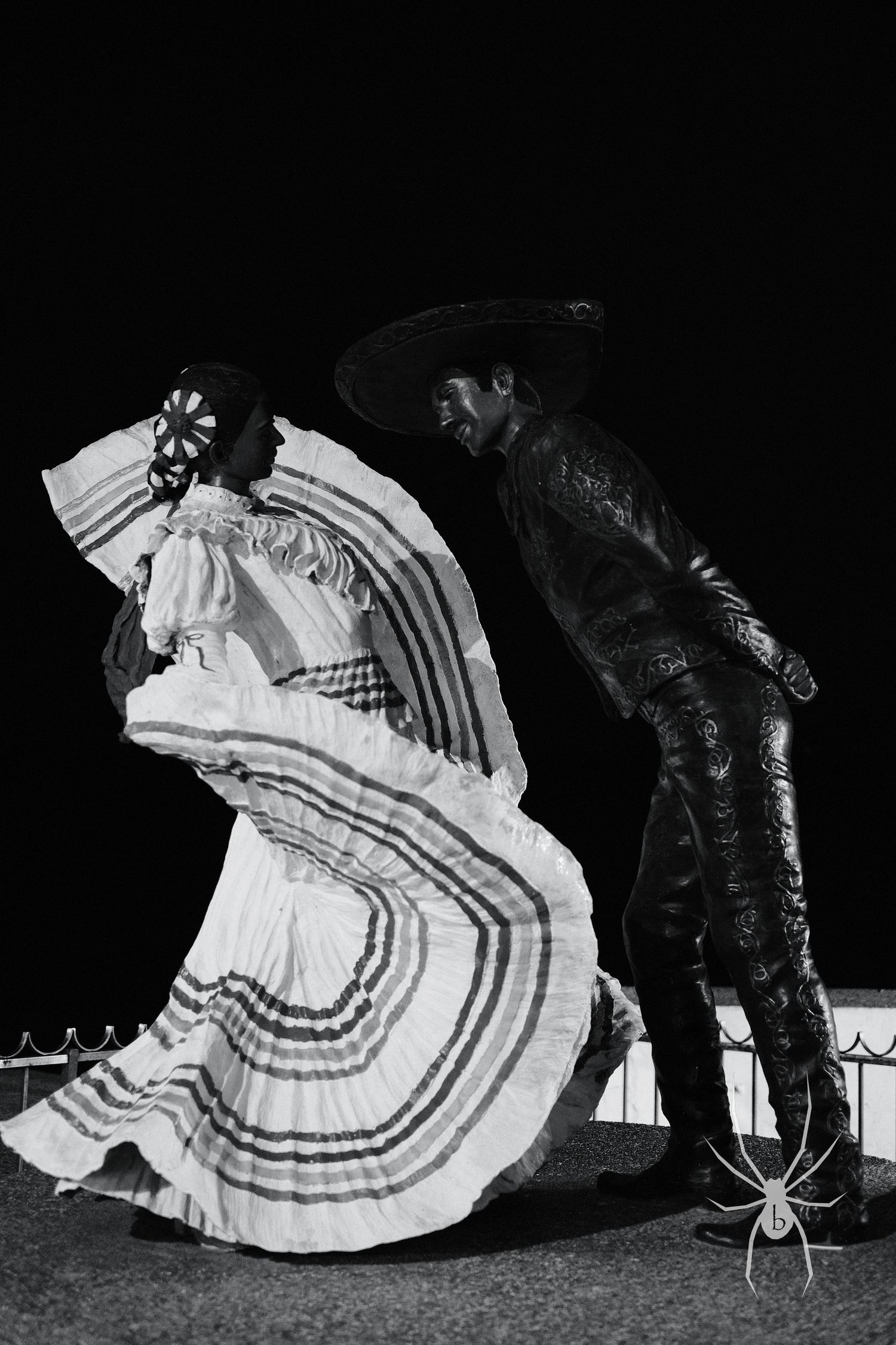 Silhouettes of traditional Mexican dancers performing at night.
