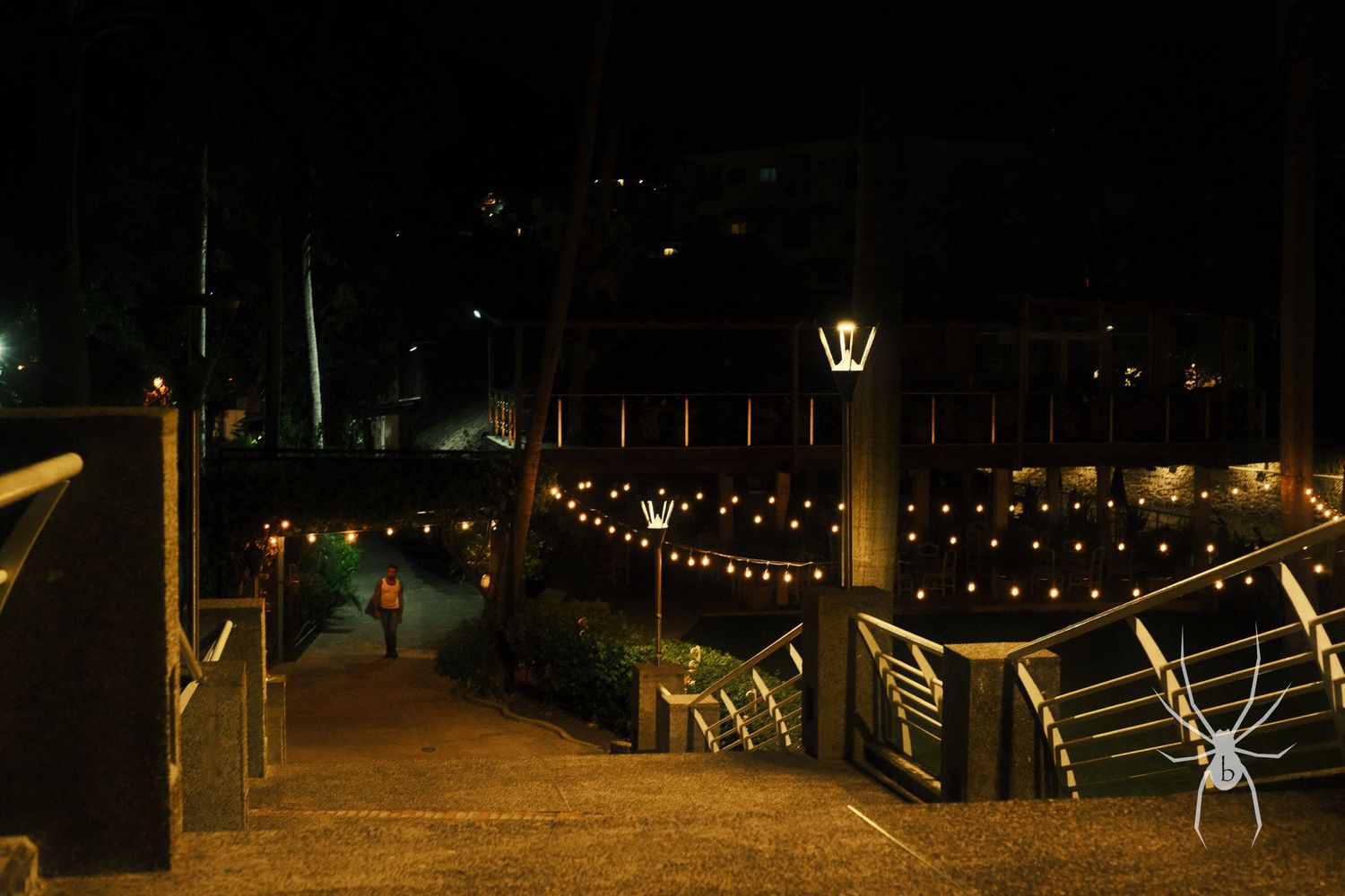 Nighttime dock with string lights illuminating the railing and walkway.