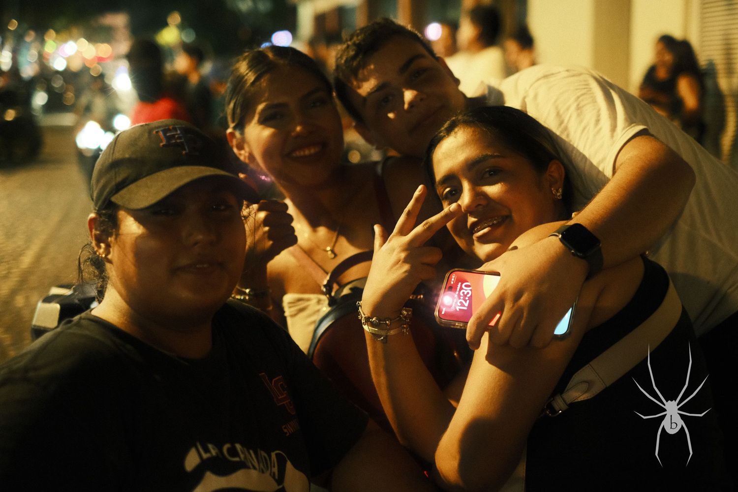 A group poses together for a casual nighttime photo.