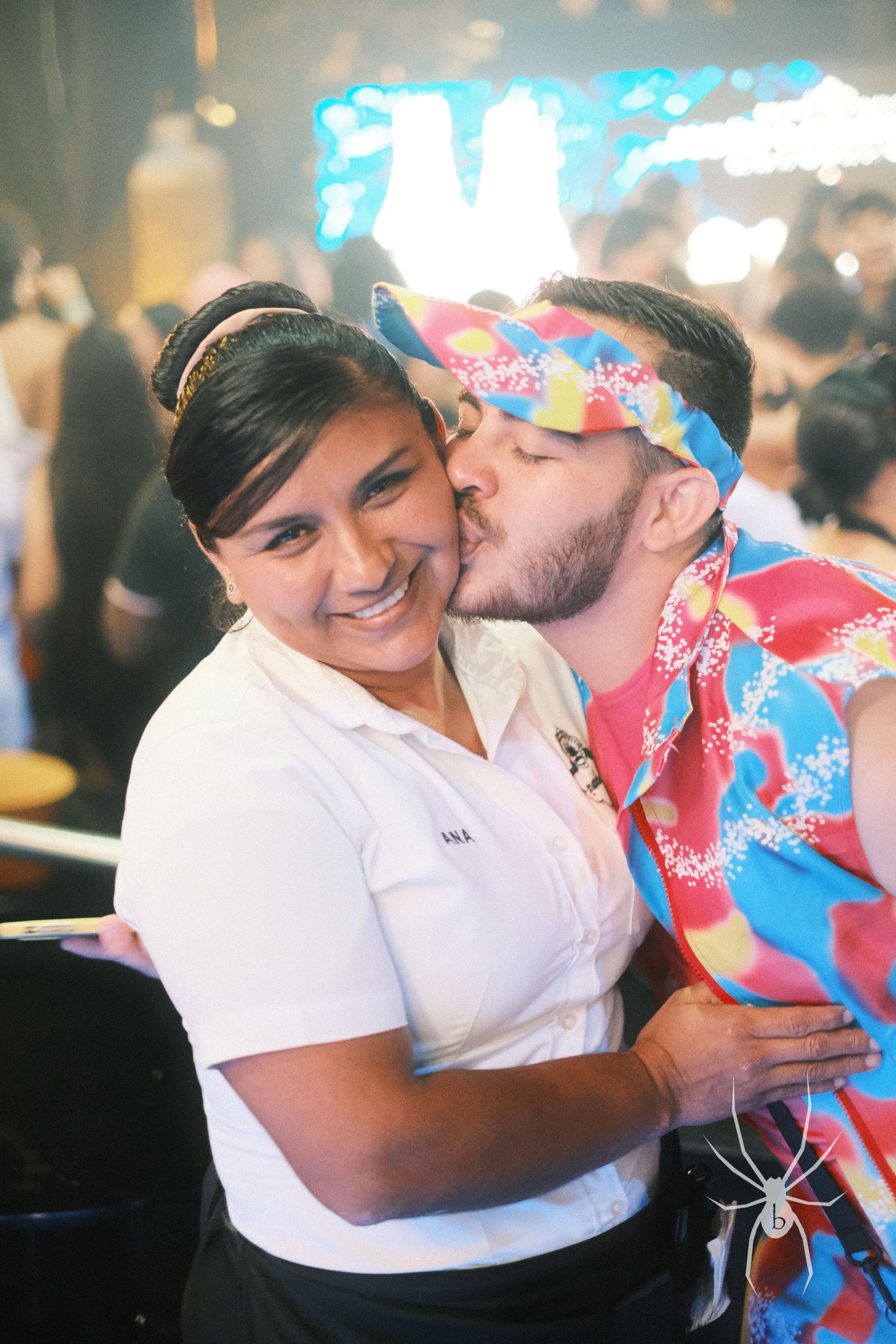 Couple sharing a tender moment at what appears to be a restaurant or party venue.