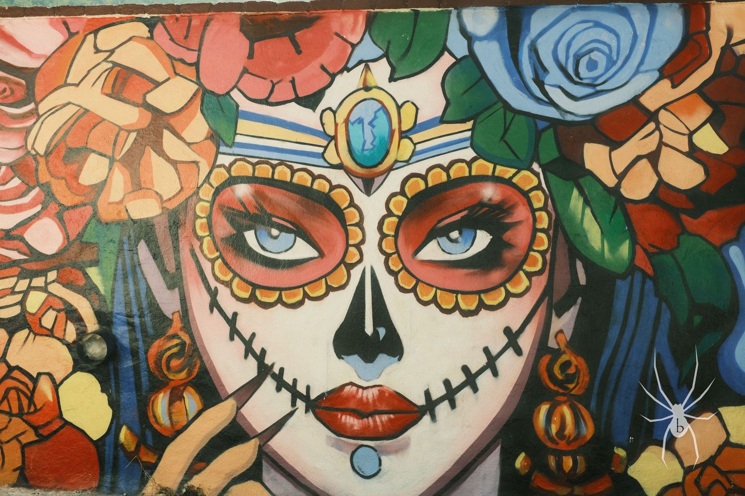 Vibrant Day of the Dead sugar skull artwork with ornate floral details and jeweled crown.