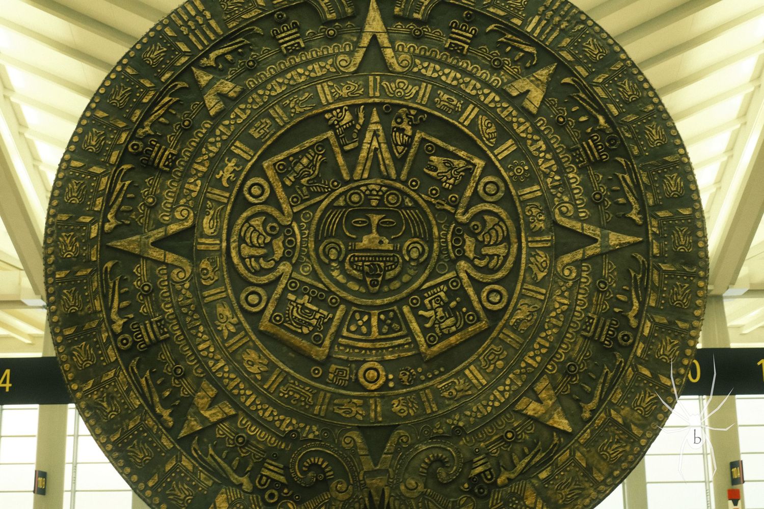 Ancient Aztec calendar stone with intricate carvings displayed in a museum.