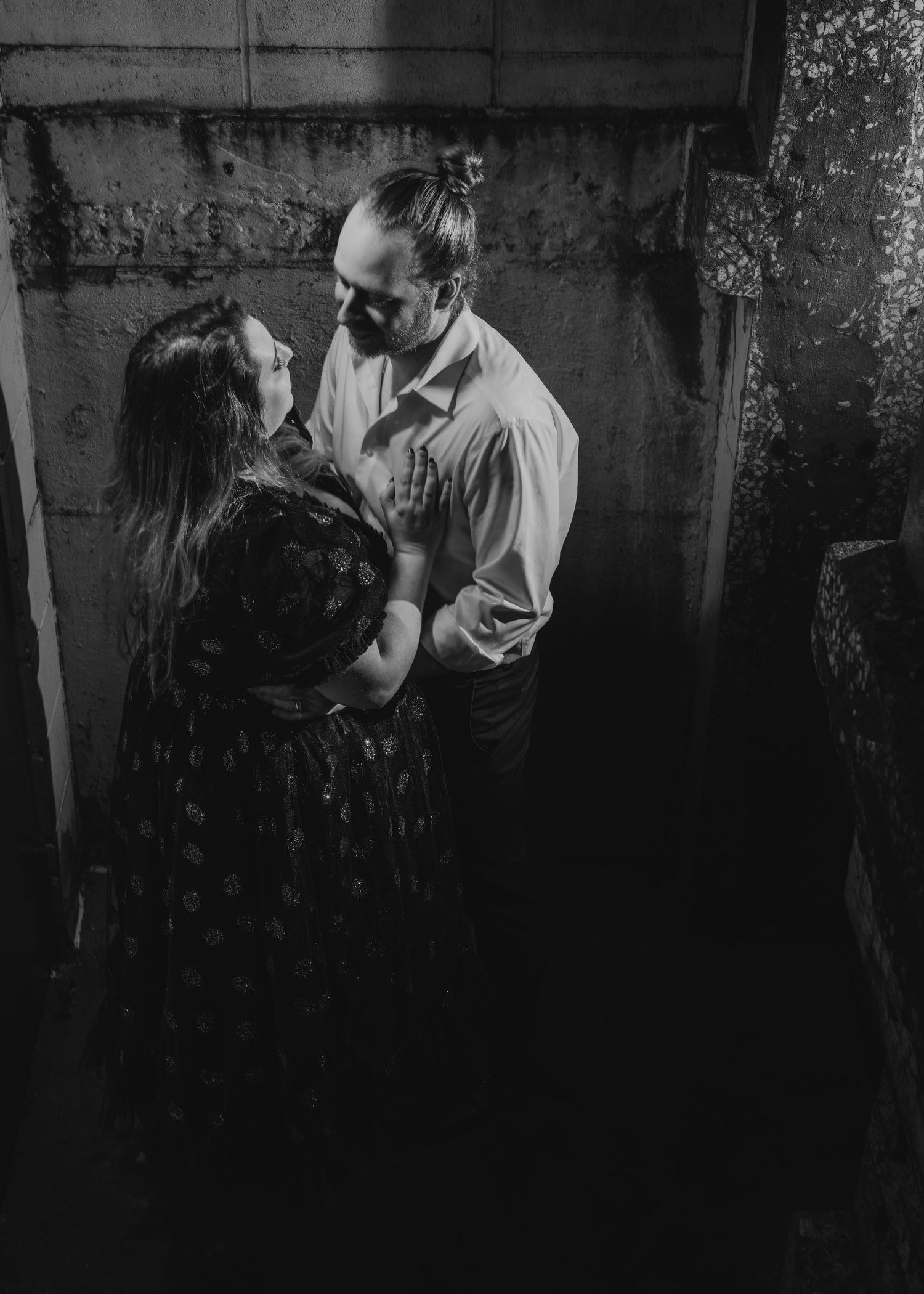 Black and white romantic photo series set against a dramatic textured wall.