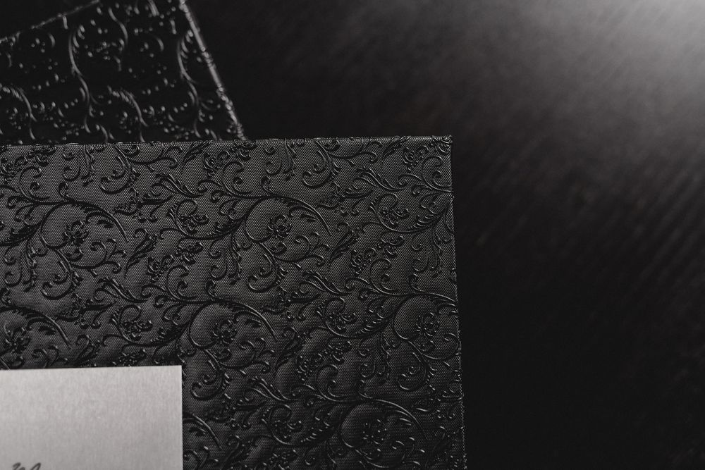 Close-up of an embossed black photo album corner with white space.