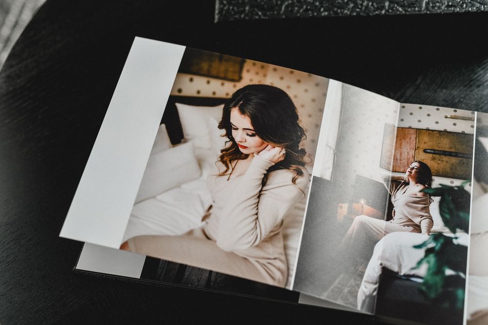 Open photo album showing artistic black and white portrait photographs on display.