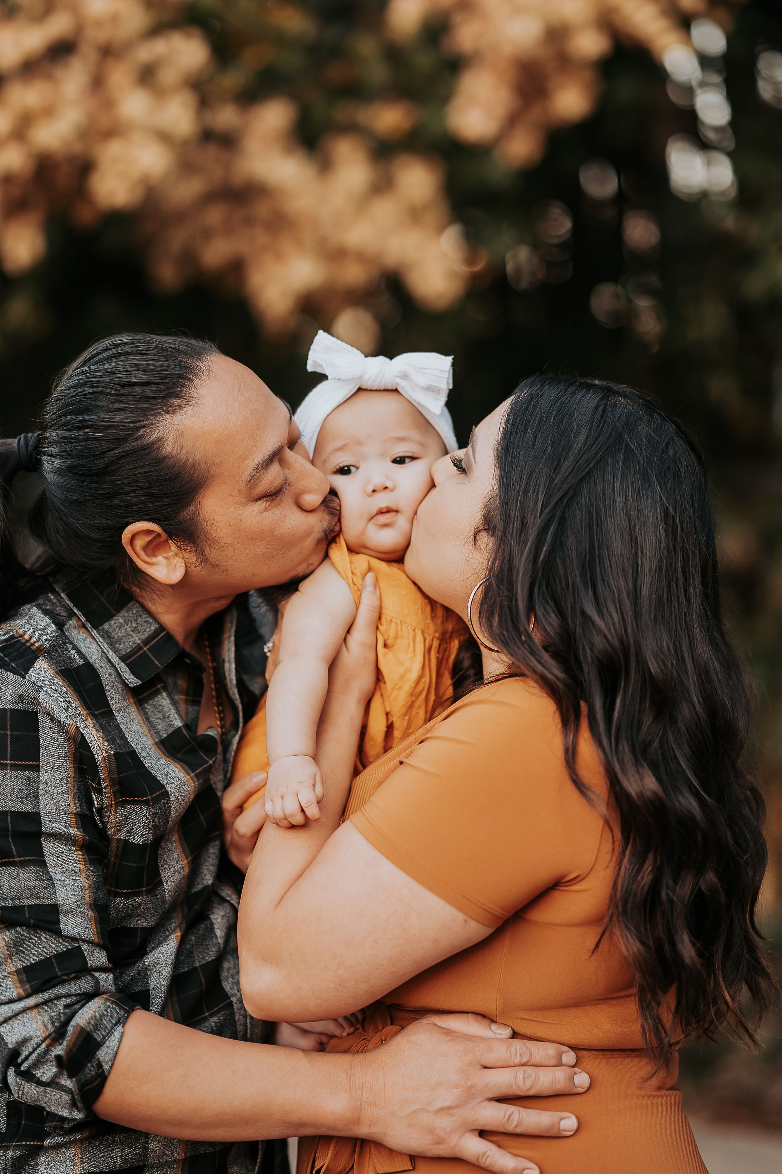 Happy family moment captured outdoors with autumn colors in background.