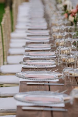Elegant table setting with crystal glassware and silver-rimmed plates at wedding reception.