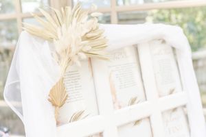White dried palm fronds arranged with elegant paper details in soft natural lighting.