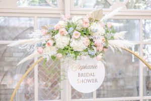Romantic floral arrangement with pink and white blooms and gold accents for a bridal shower.