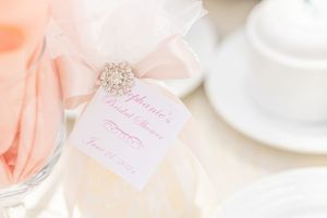 Elegant peach-colored drink with delicate white tag and rhinestone accent for a bridal celebration.