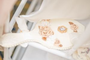 White wedding garter with delicate floral and pearl embellishments.