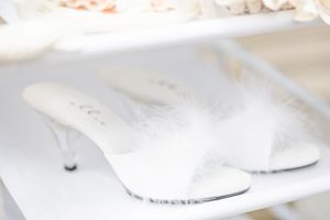Elegant white bridal heeled sandals displayed on a light surface.