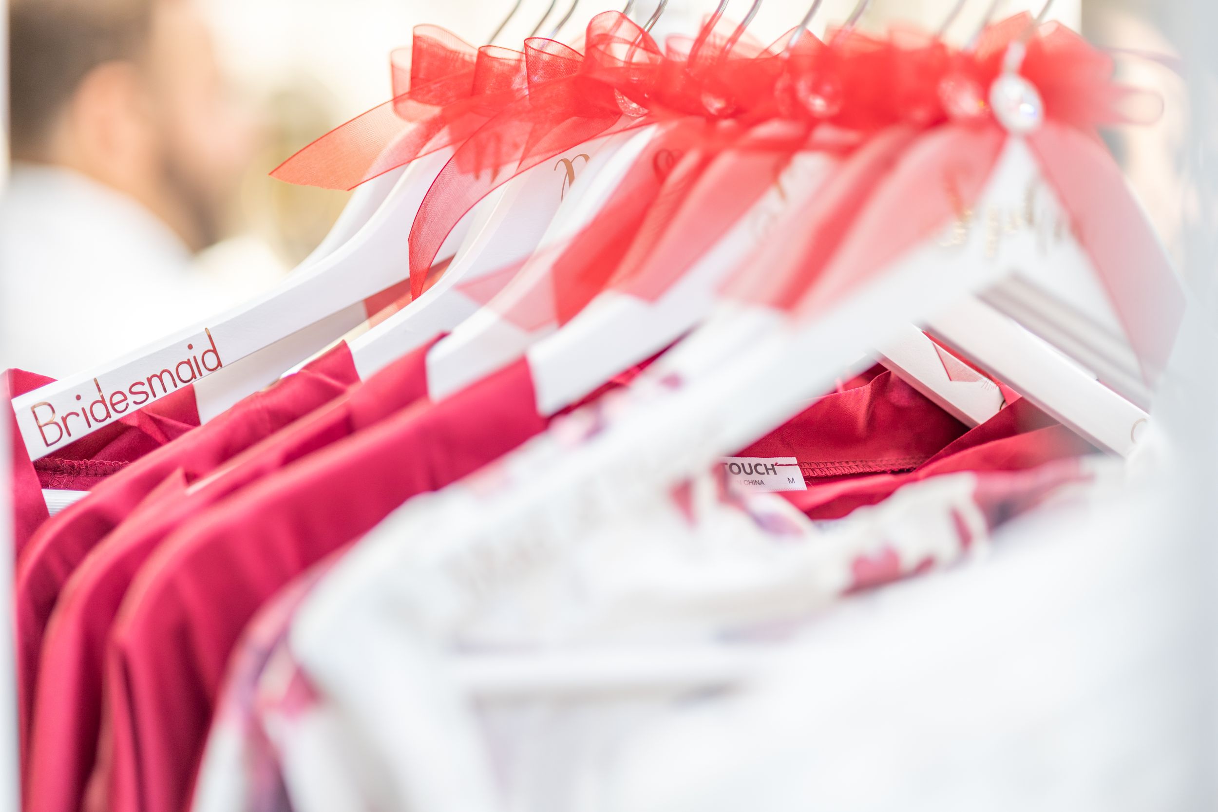 Close-up view of pink and white wedding robes displayed on matching hangers.