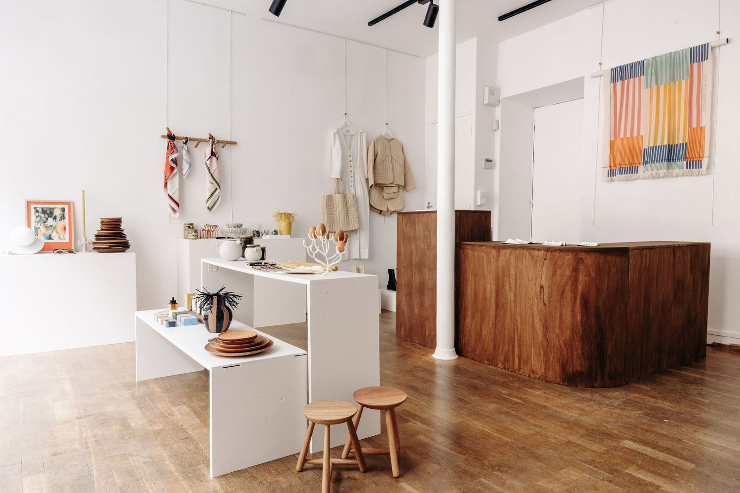 Minimalist retail store interior with white display shelves and wooden accents.