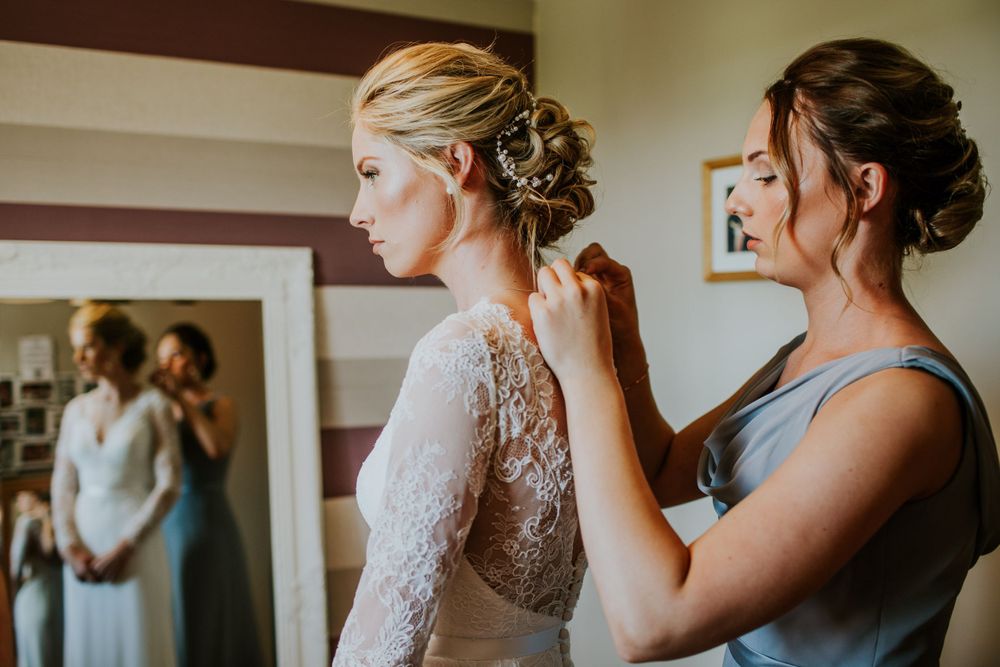 Wedding preparation moment showing detailed lace dress.