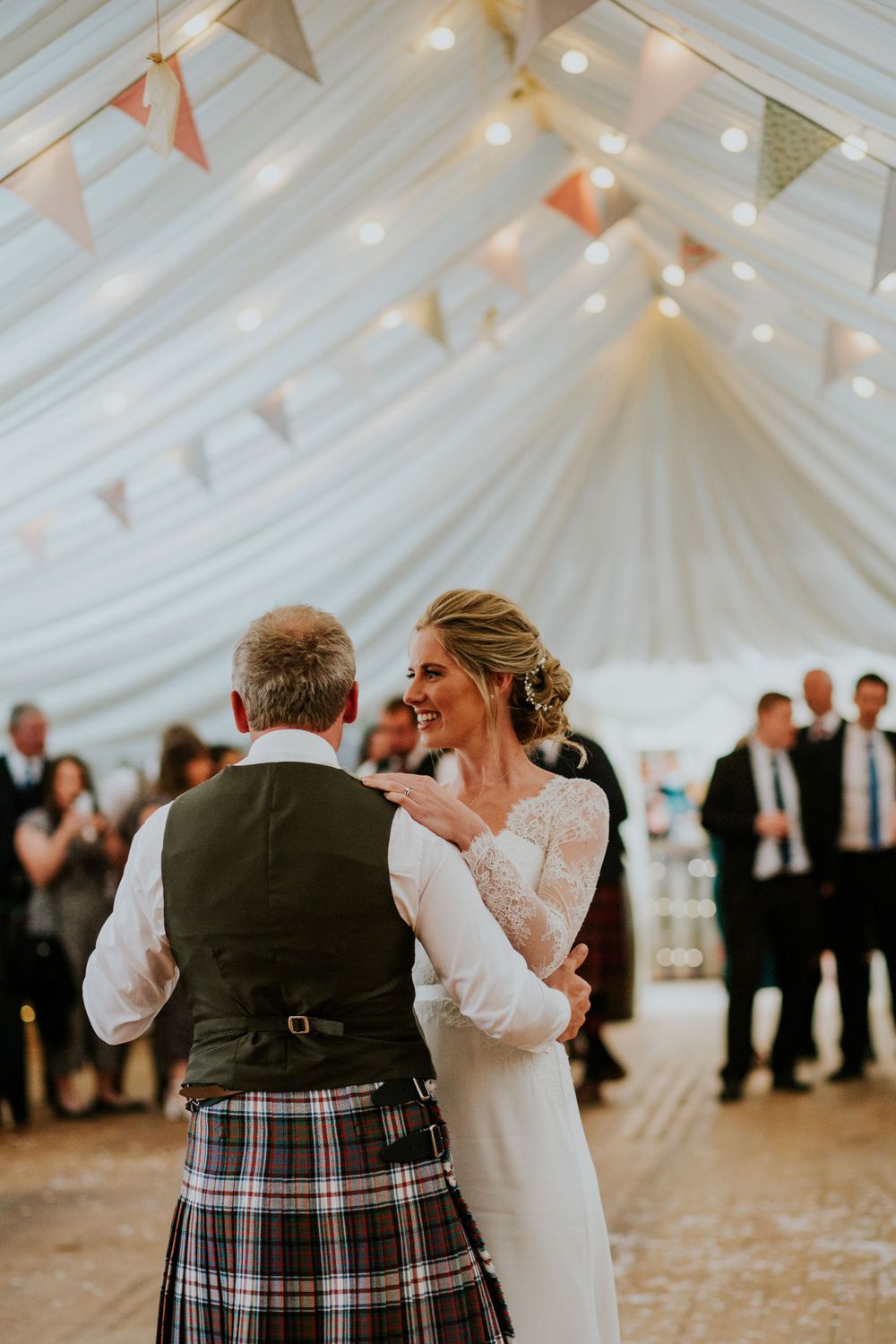 Romantic first dance in a beautifully decorated marquee with white draping and bunting.