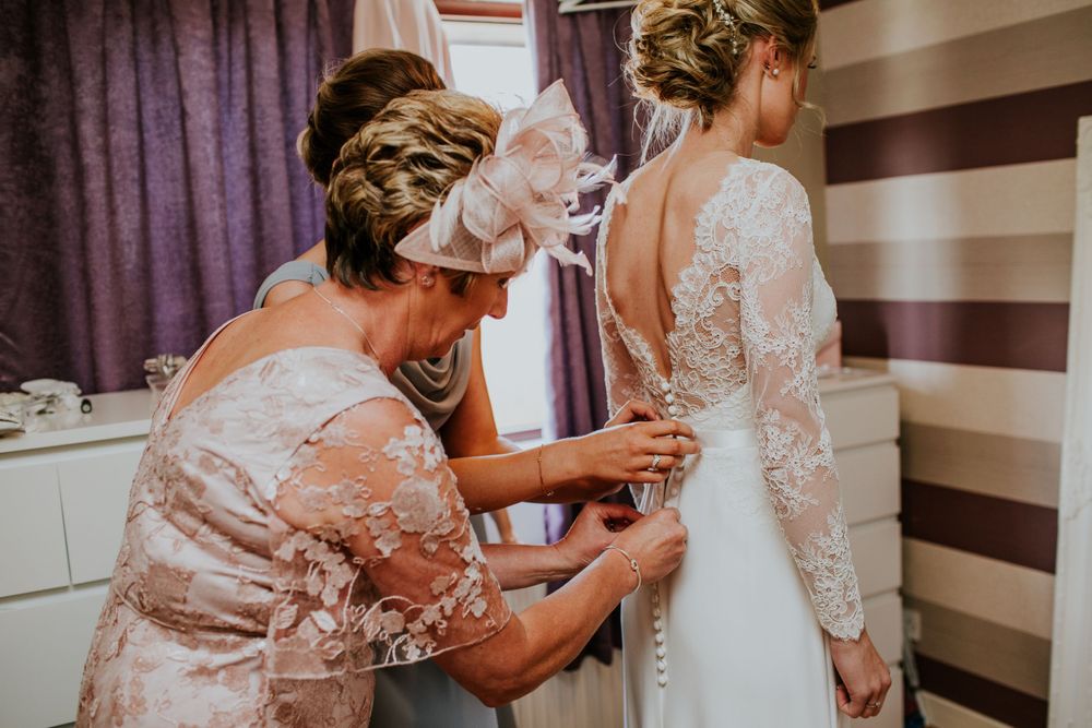 Wedding dress preparation scene with elegant lace detailing.
