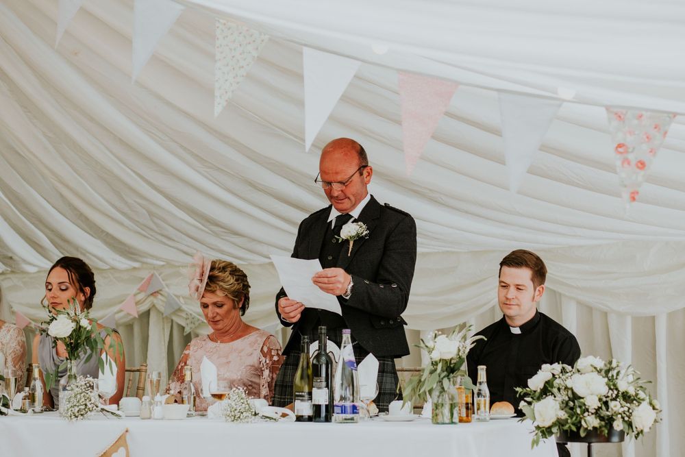 Wedding reception speech being delivered at the head table during celebrations.