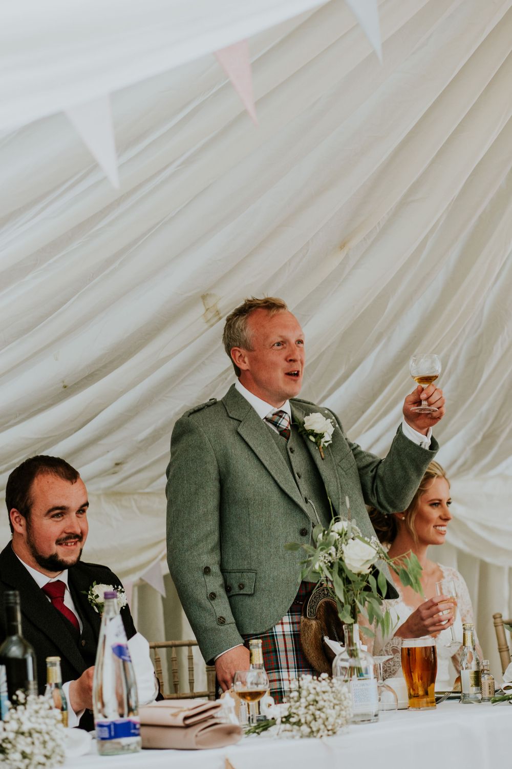 Wedding speech being delivered at reception under white marquee tent.