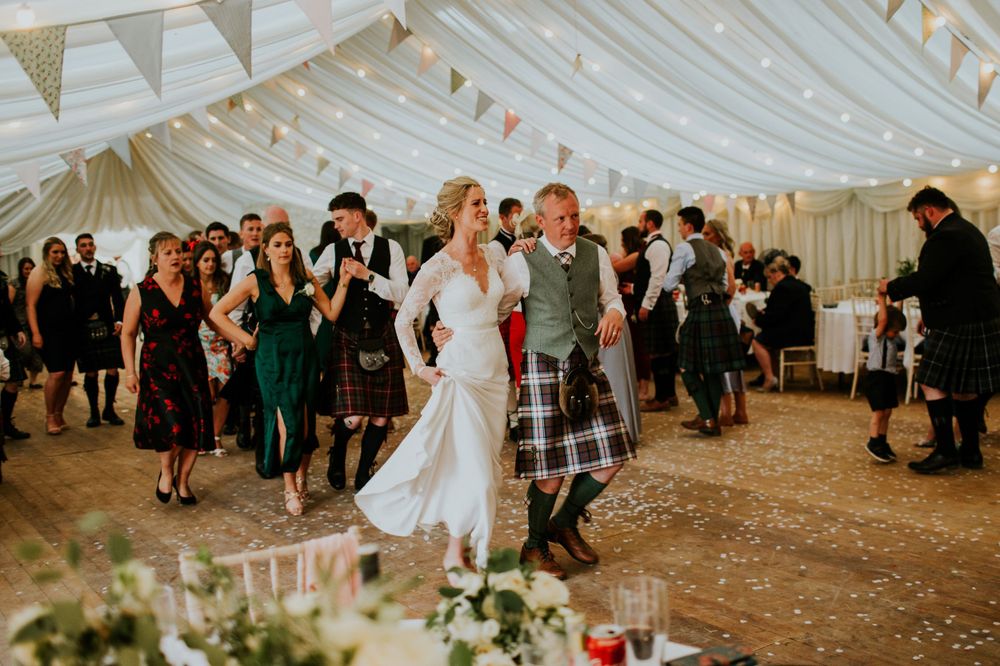 Traditional Scottish wedding reception with dancing in a decorated marquee tent.