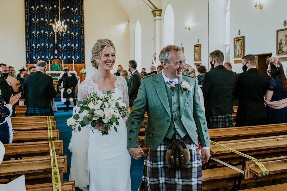 Traditional Scottish wedding ceremony in a church with the couple walking down the aisle.