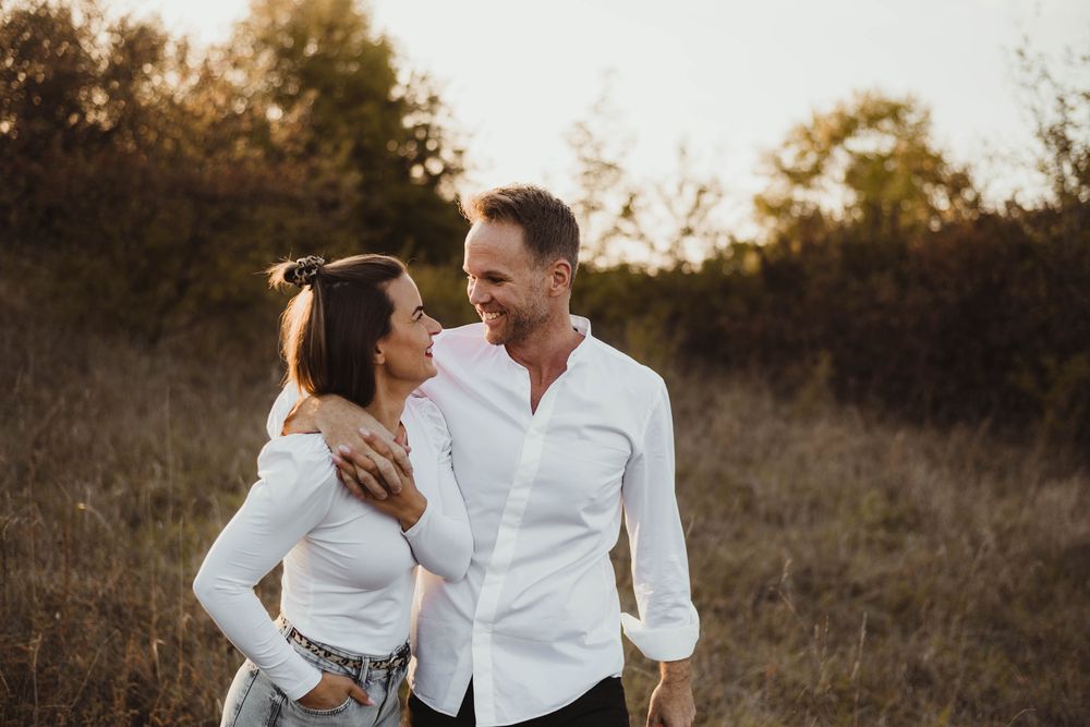 Intimate outdoor portrait session in a rustic field during golden hour.