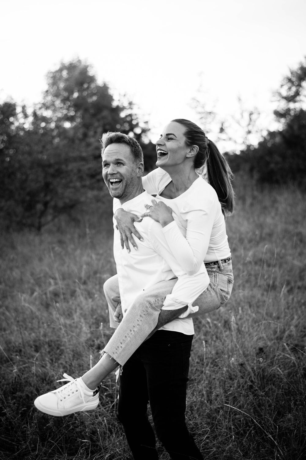 Joyful black and white candid photo in a natural outdoor setting.
