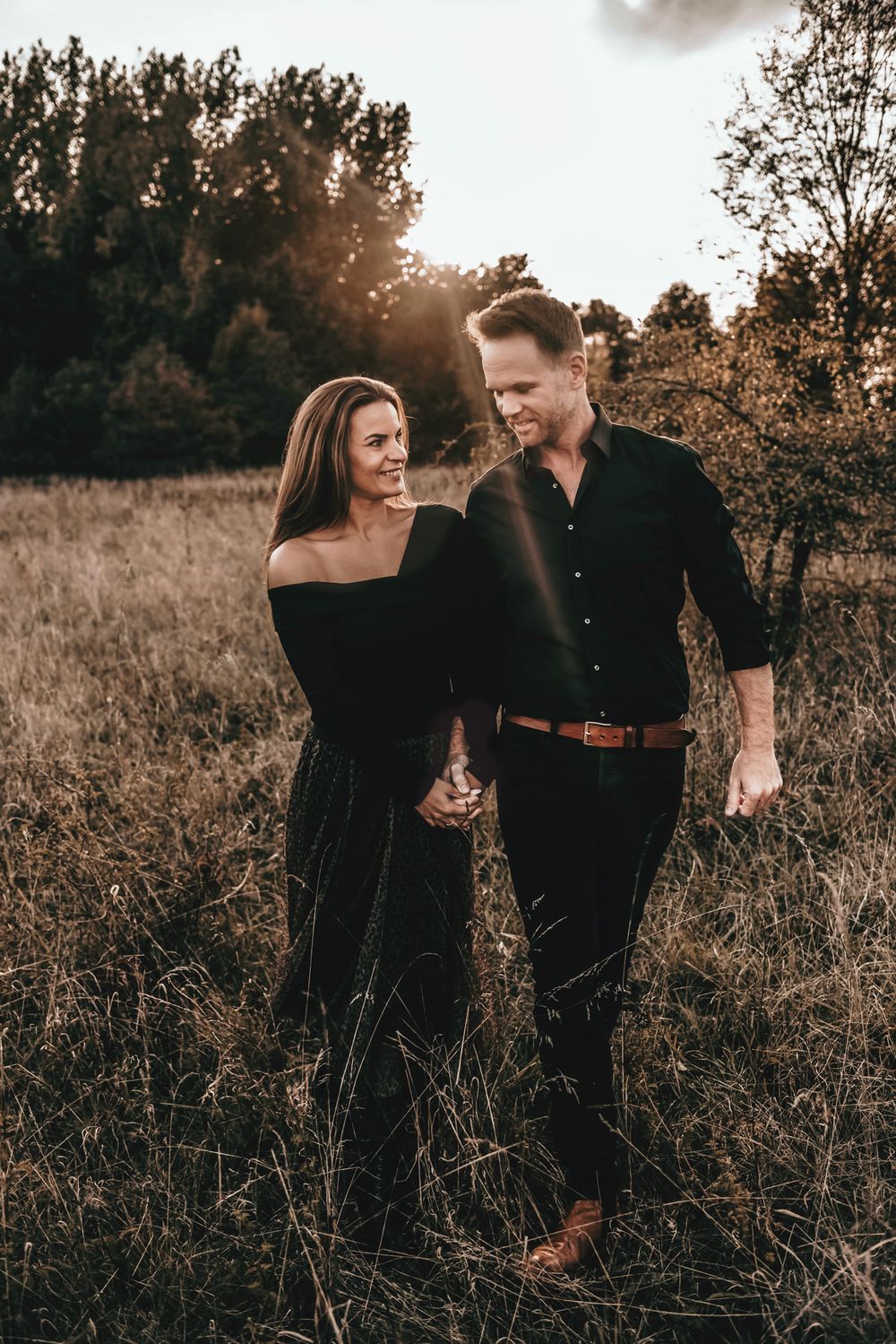 Romantic sunset portrait in a field with warm autumn tones and natural lighting.