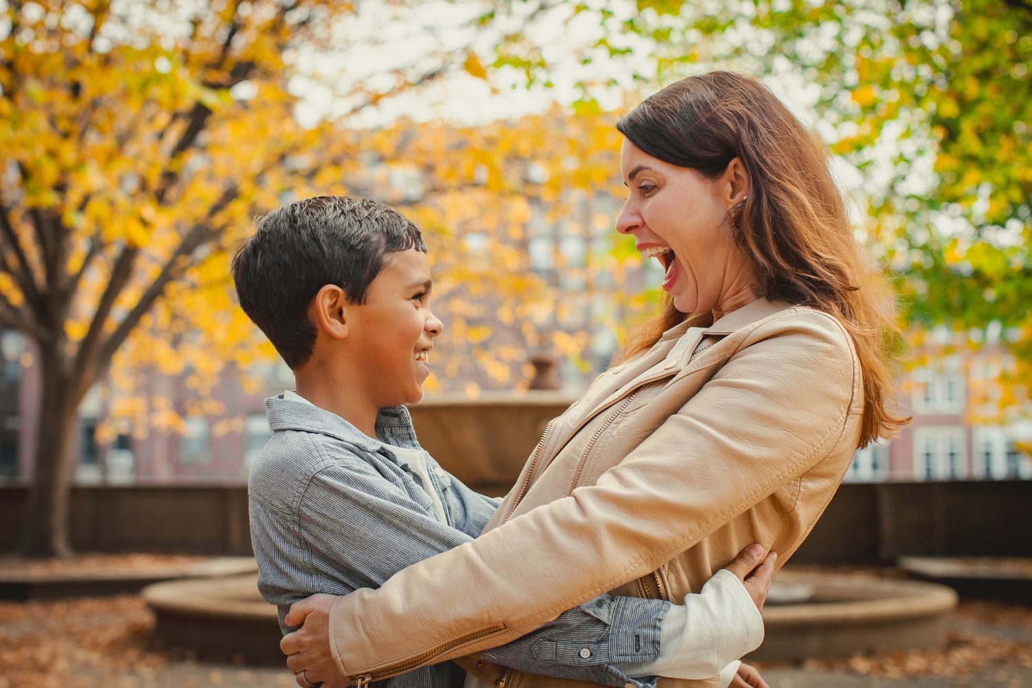 Candid moment of joy shared between family members during autumn day.
