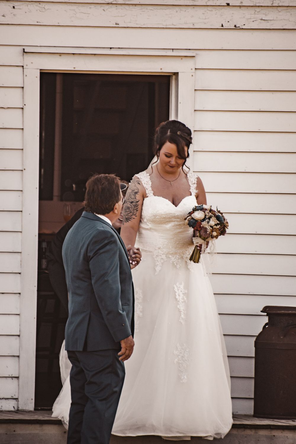 A couple sharing a moment outside a white building during their wedding.