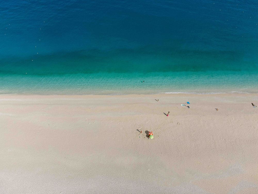 Aerial view of a pristine white sandy beach meeting turquoise waters.