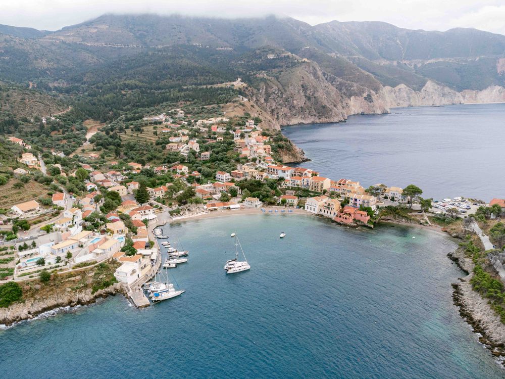 Aerial view of a picturesque coastal town with boats docked in a protected harbor.