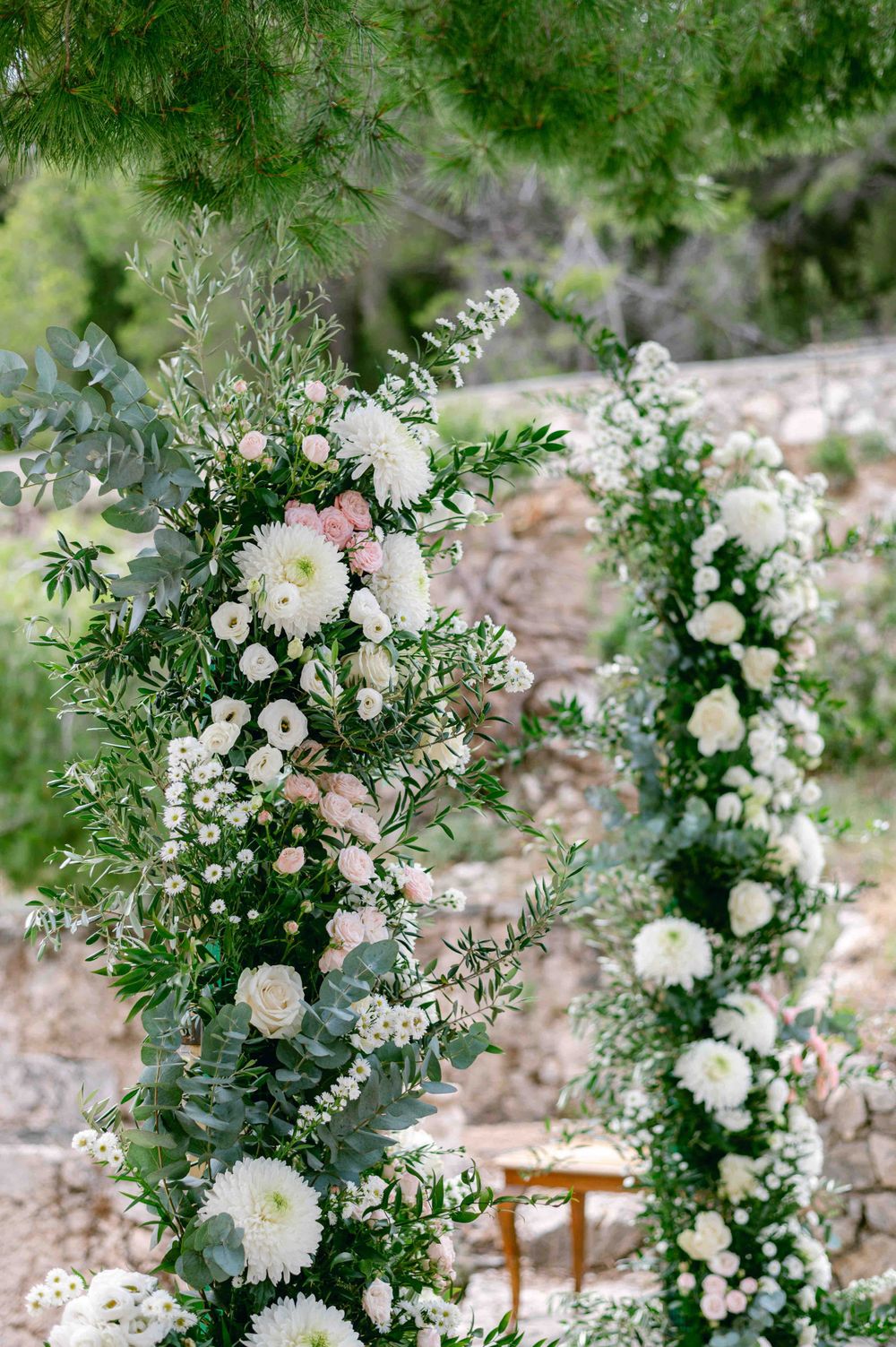 Romantic wedding arch decorated with white and pink flowers and greenery.