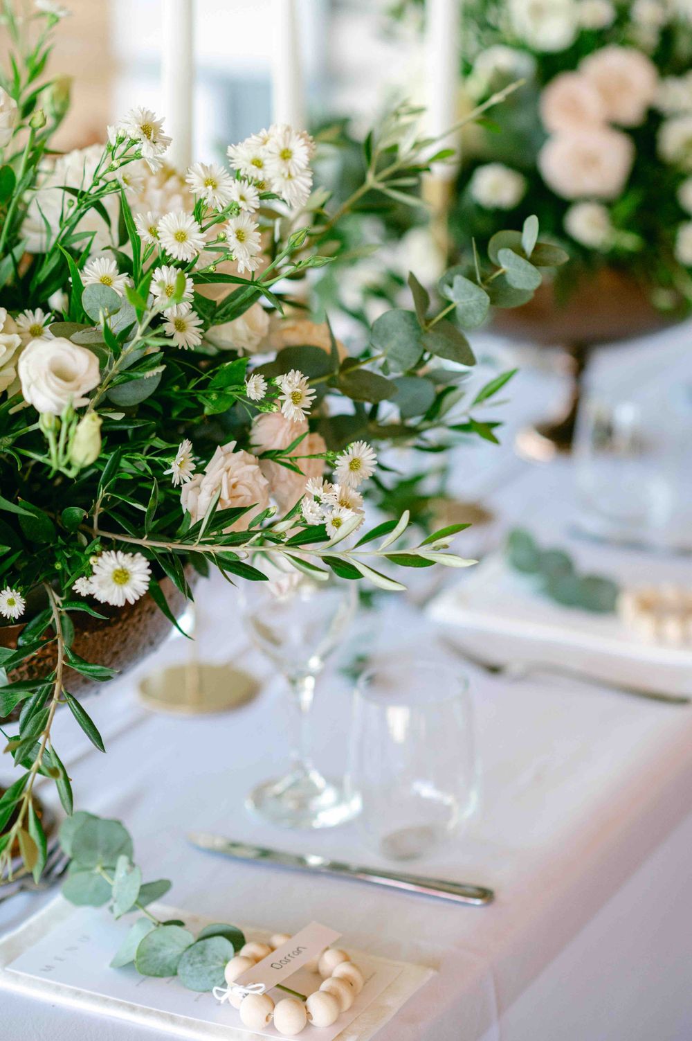 Close-up of wedding table setting with delicate floral arrangement and place settings.