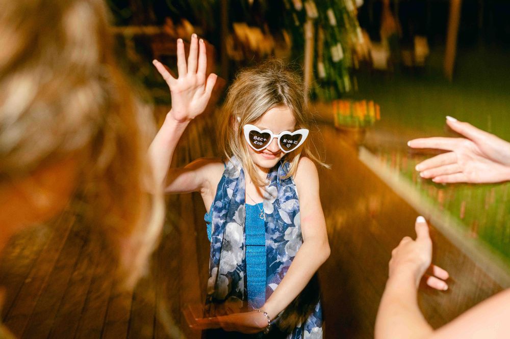 An energetic dance party scene with people wearing heart-shaped sunglasses and having fun.