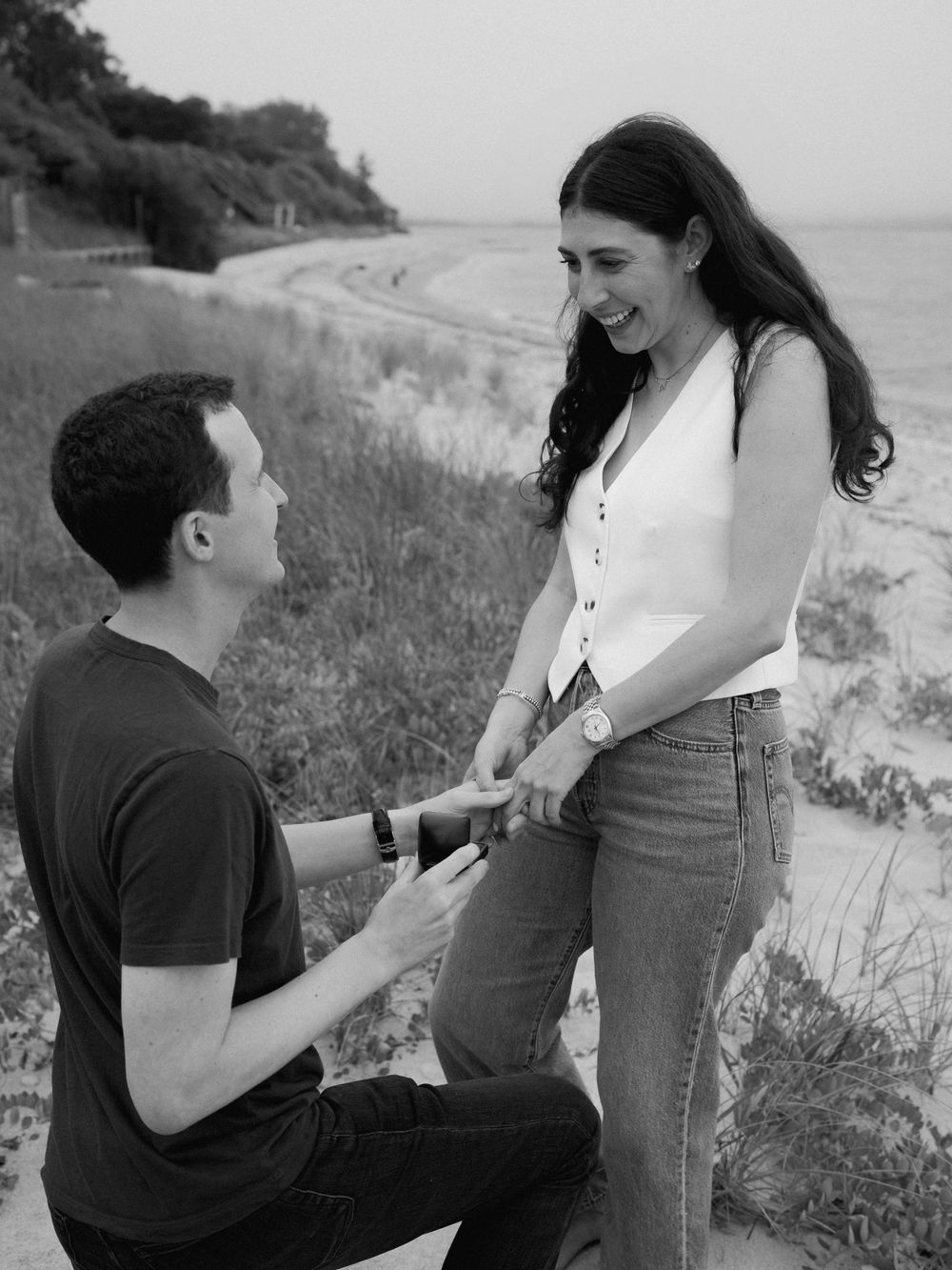 A romantic seaside marriage proposal taking place on a cliff overlooking the ocean.