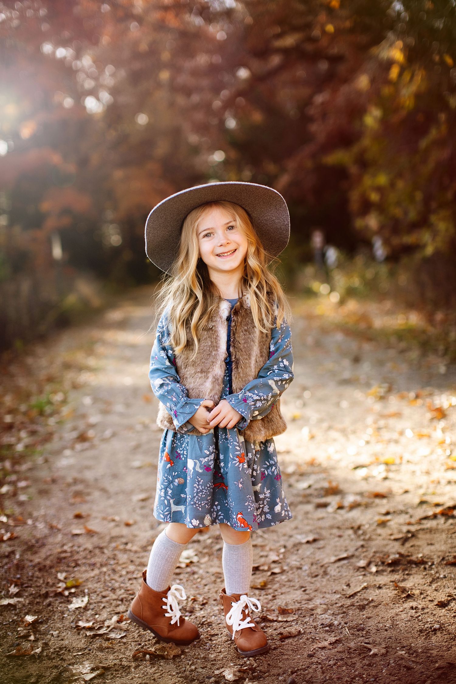 Young girl in stylish family session wardrobe with a gray hat during a Minnesota fall leaves photography session