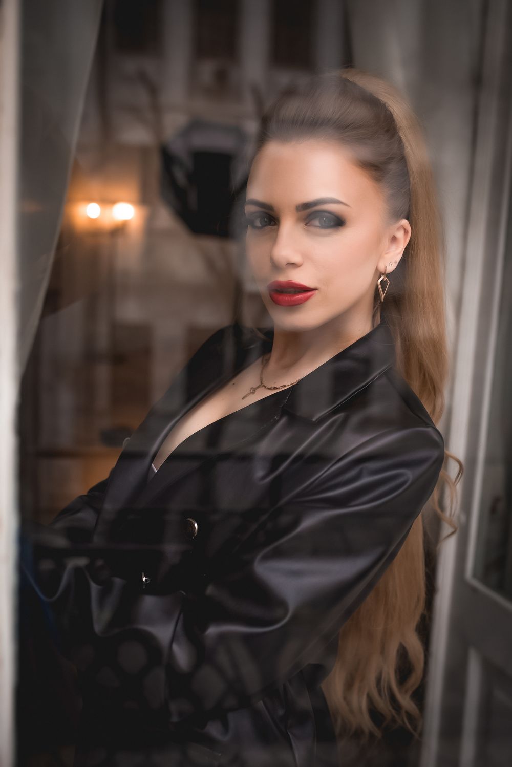 Elegant portrait series featuring black satin clothing in moody indoor lighting.