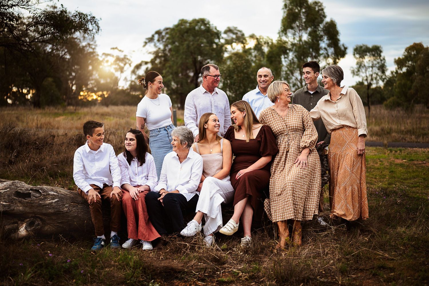Large family sitting on log laughing with each other Dubbo Photographer
