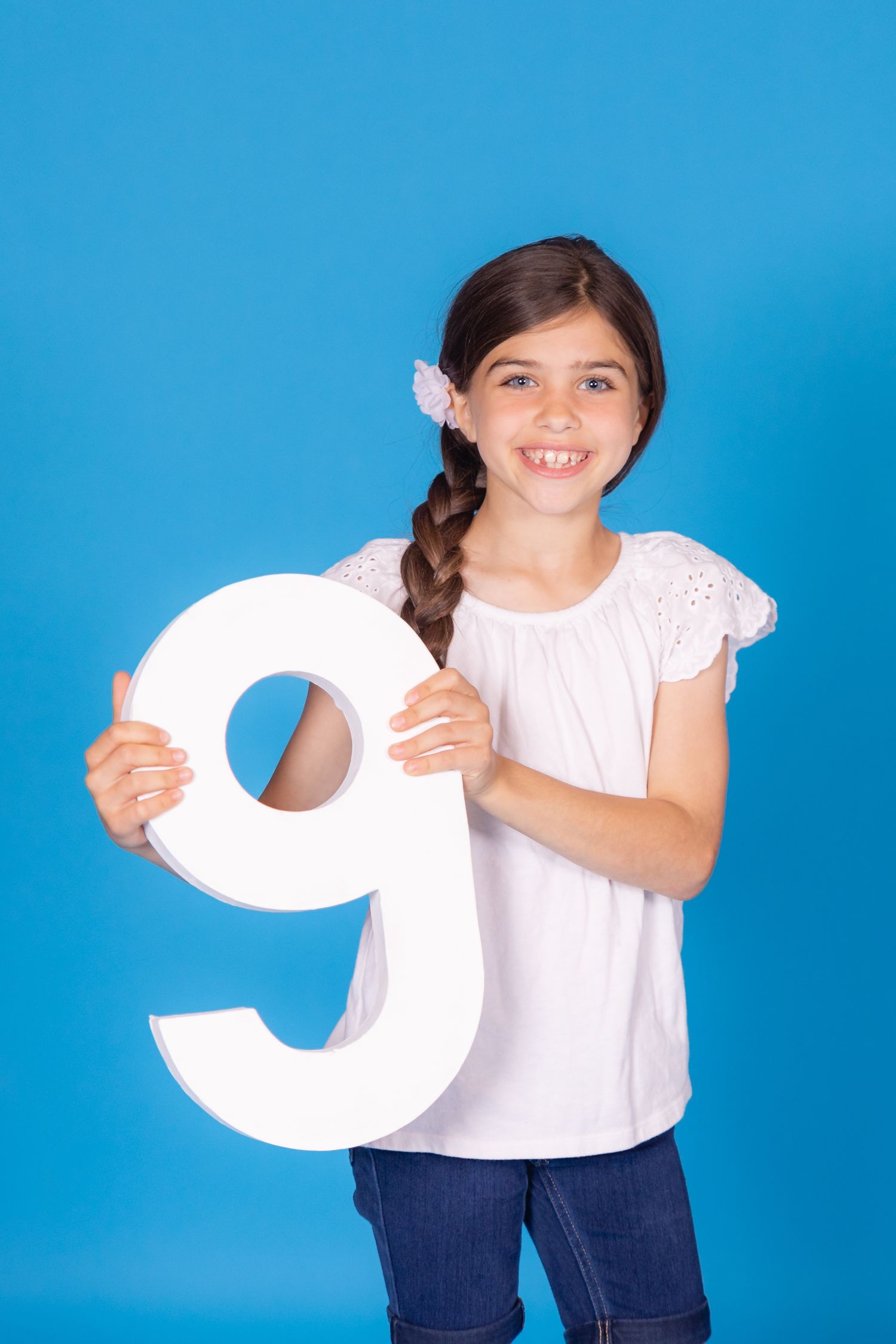 girl looking through large 9 on savage blue jay backdrop in studio clayton new jersey gloucester county