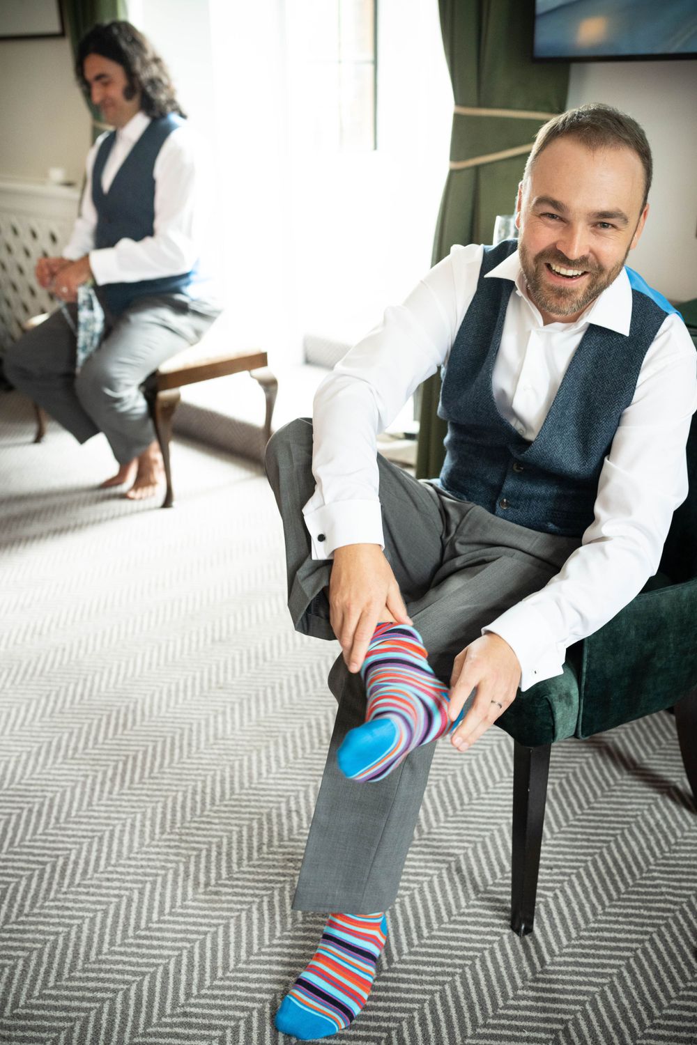 groom puts on striped socks in the elvetham hotel
