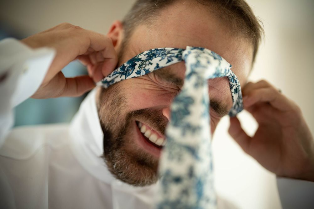 groom puts on pre tied tie