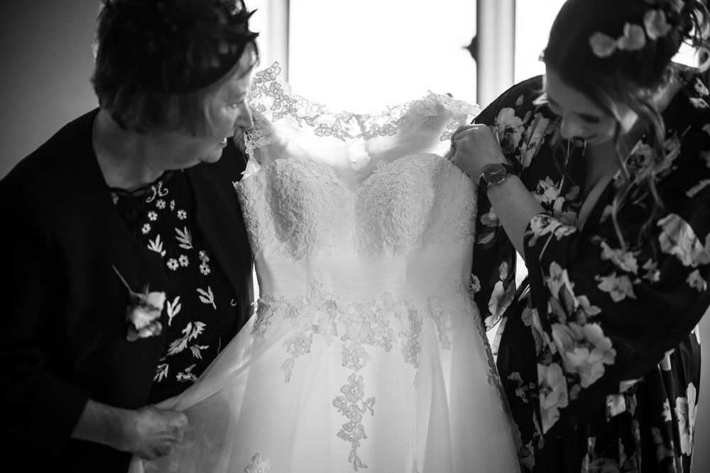 mum and bride inspect wedding dress during bridal preparations at the elvetham hotel