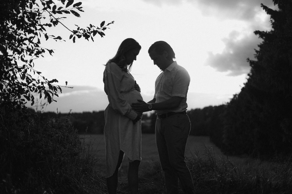 A silhouetted couple sharing an intimate moment against a dusky sky.