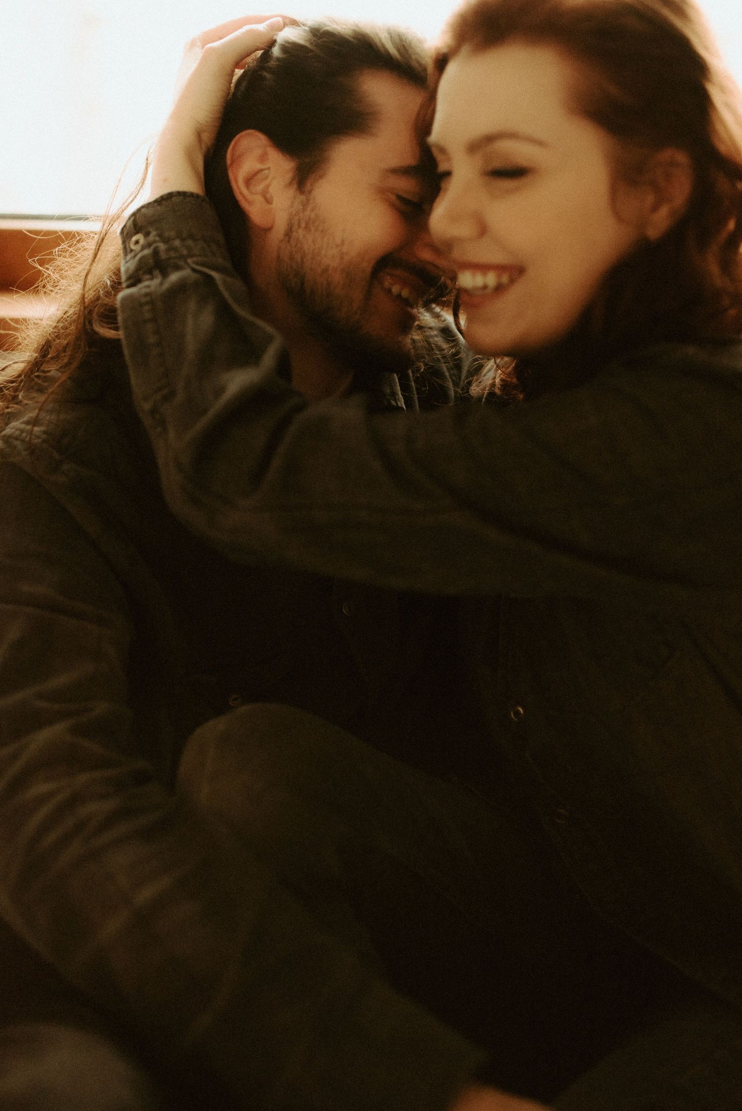 Intimate couple sharing a tender romantic moment in warm lighting.
