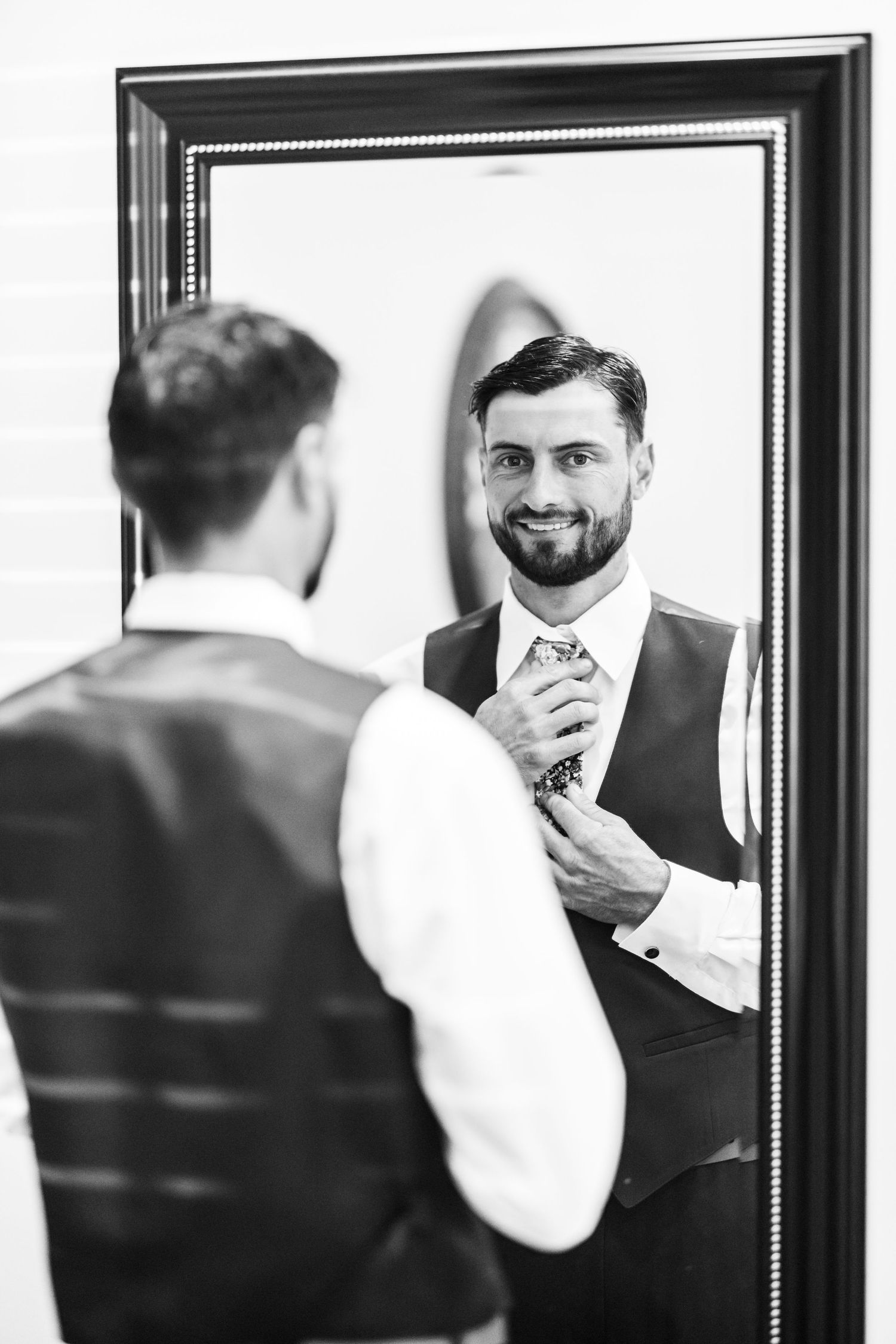 Series of mirror reflections showing groom adjusting his tie and getting ready for the wedding.