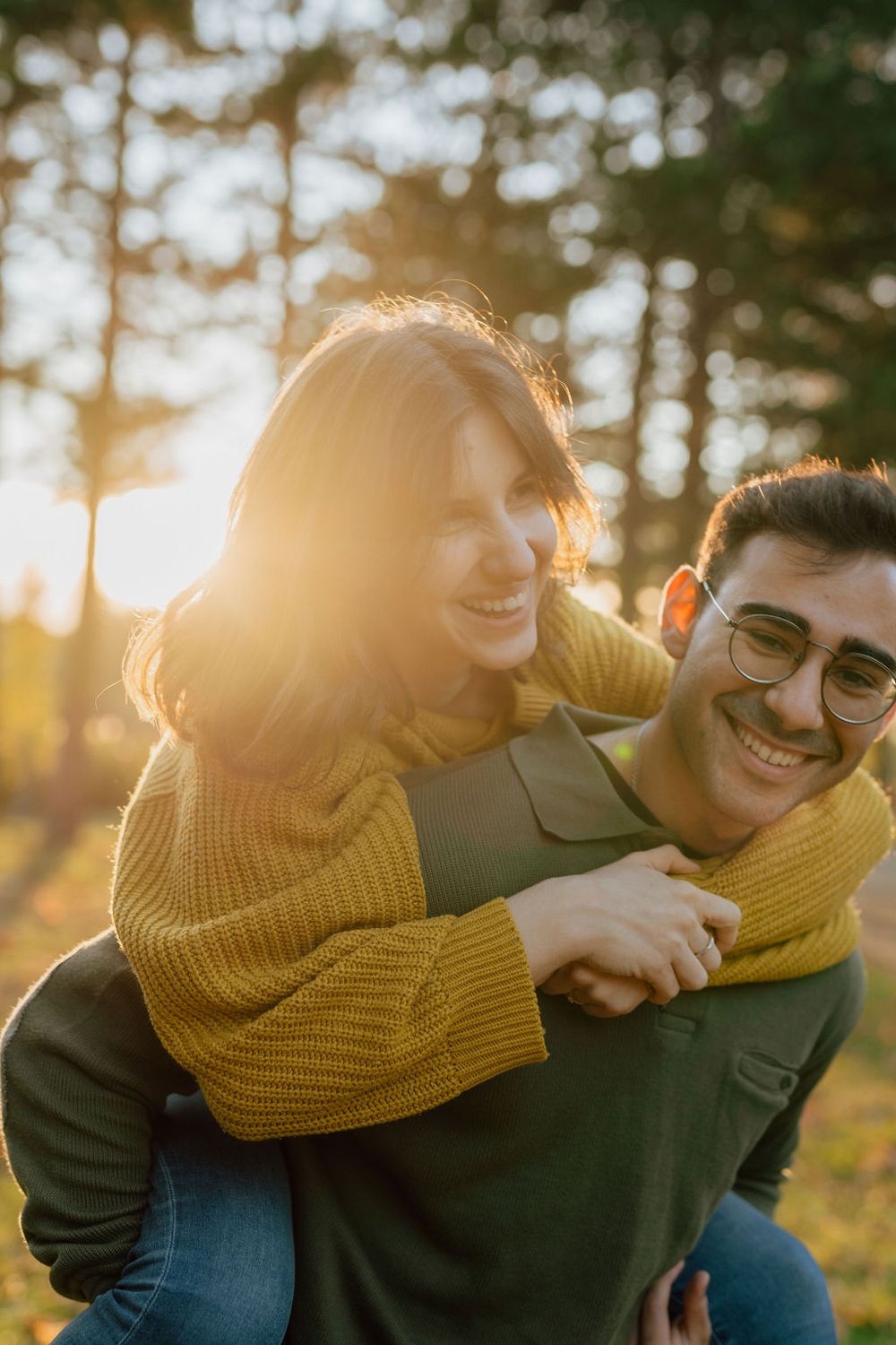 Playful piggyback moment captured in warm sunset lighting.