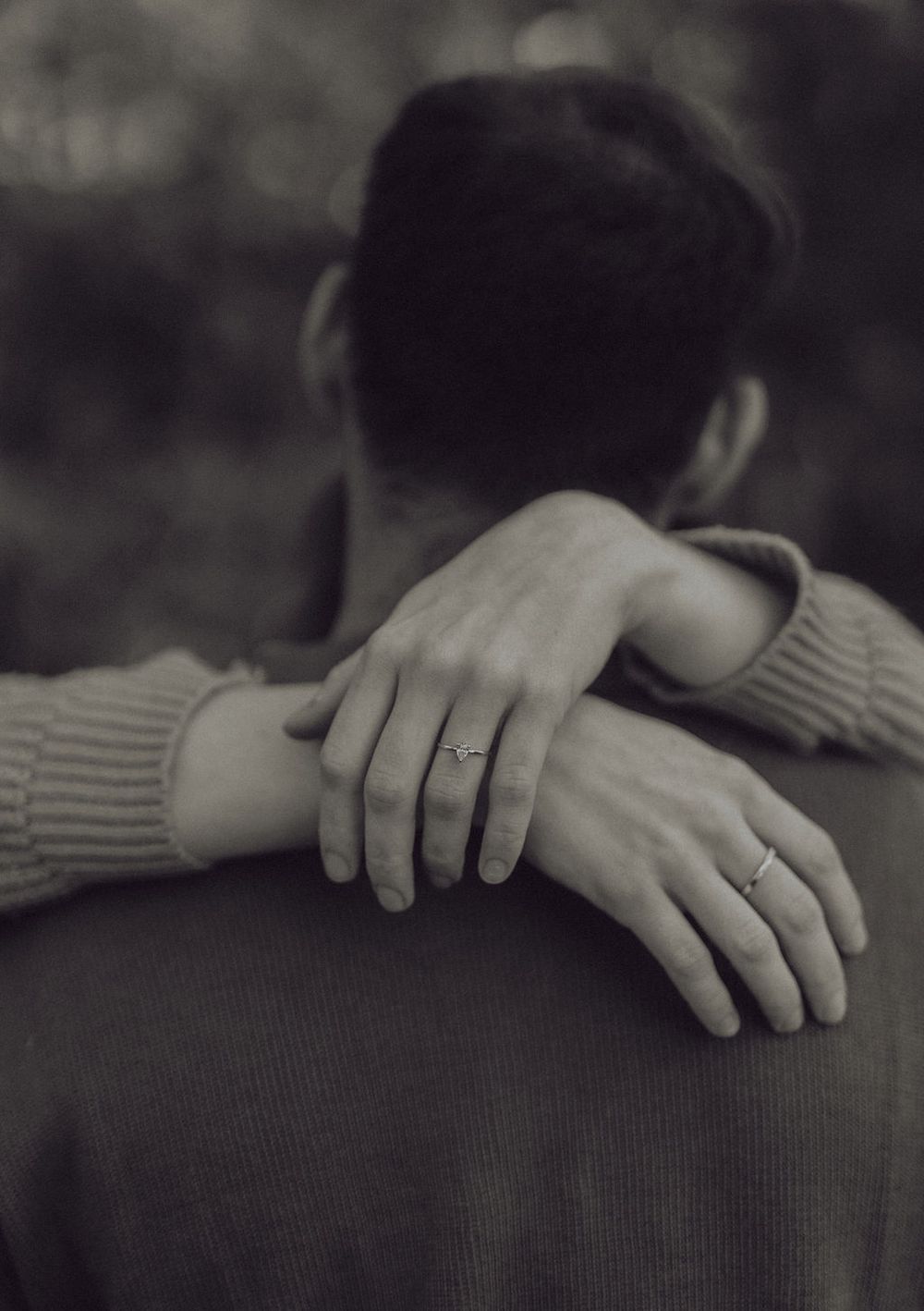 Close-up of hands with wedding rings in an affectionate embrace.