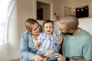 A joyful family moment shared in a sunlit living room with warm, natural lighting.