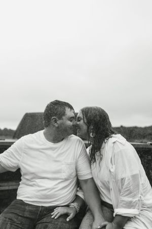 A romantic black and white photo of a couple sharing a tender moment outdoors.